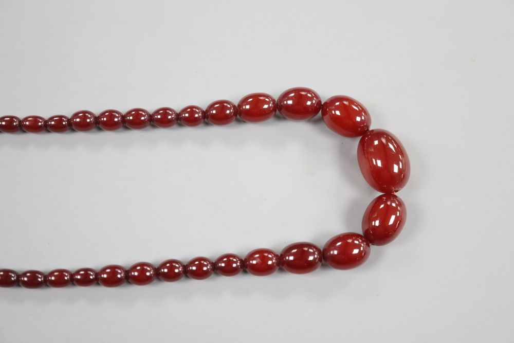 A single strand graduated simulated cherry amber oval bead necklace, 69cm, gross 54 grams.